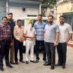 : Punjab Vigilance Bureau officials standing beside a man whose face is covered with a white cloth.